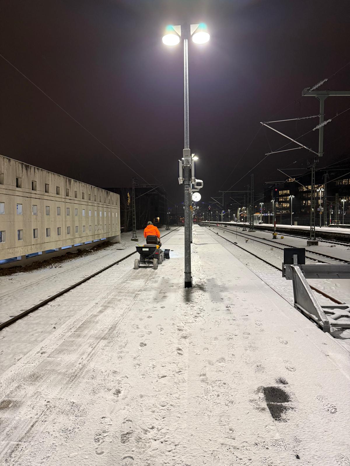 Nächtlicher Winterdiensteinsatz auf verschneiten Bahnsteigflächen